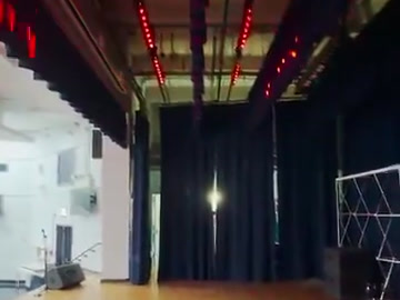 Red LED stage lighting with the stage and curtains in view.